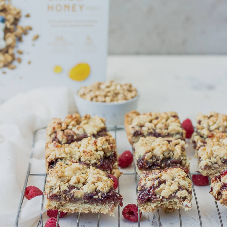 Recipe image of raspberry crumble bars made with Cascadian Farm Organic Oats and Honey Granola, with fresh berries