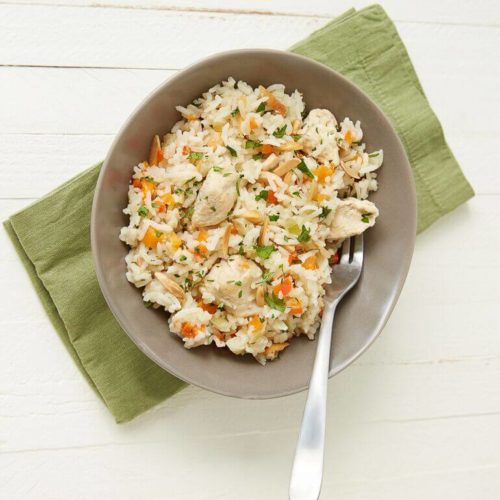 Recipe image of a bowl of one pot herbed chicken and rice, with a fork